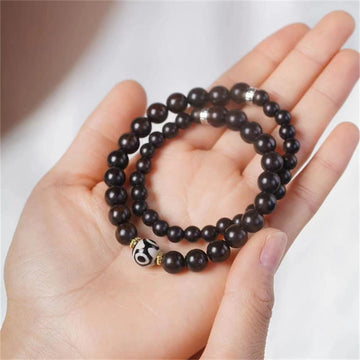 Pulsera Tibetana de Madera Ébano con Cuenta Dzi – Doble Vuelta